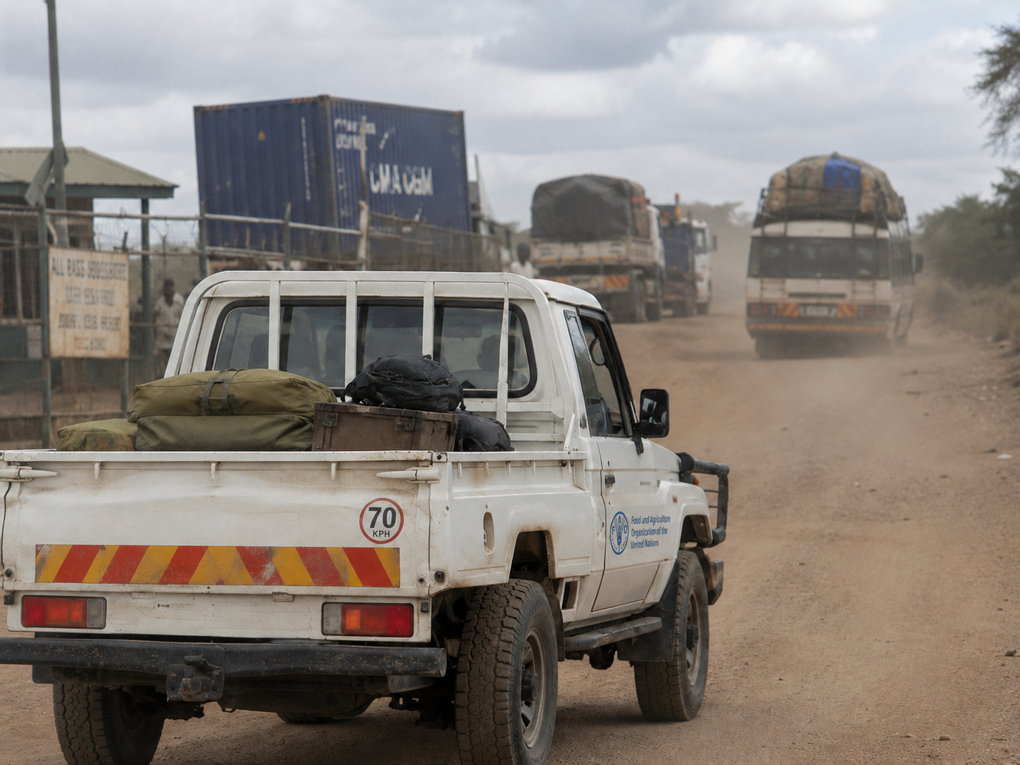 Fleet pick-up and trucks travelling on a dusty rural African road